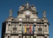 Fachada del Ayuntamiento de Pamplona con su reloj y banderas