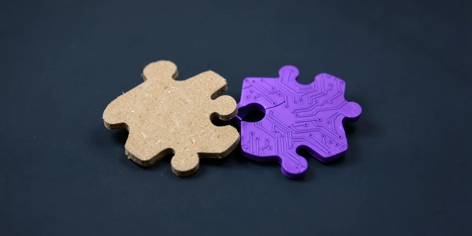 Pieza de puzle de cartón que encaja con otra violeta con circuitos, la digitalización de una pyme paso a paso
