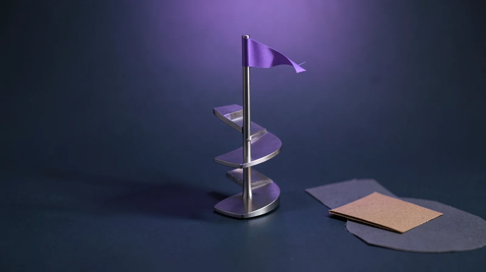 Escalera de caracol metálica en miniatura con un banderín violeta en lo alto, bajo una luz violeta