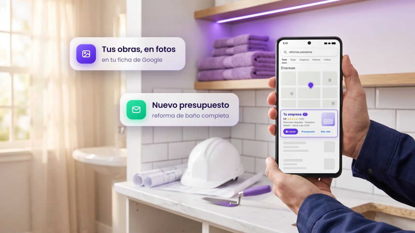 Manos con ropa de obra y un móvil con una empresa de reformas la primera en Google Maps, en un baño reformado